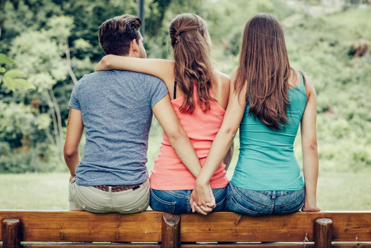 threesome-man-and-women-sitting-on-bench