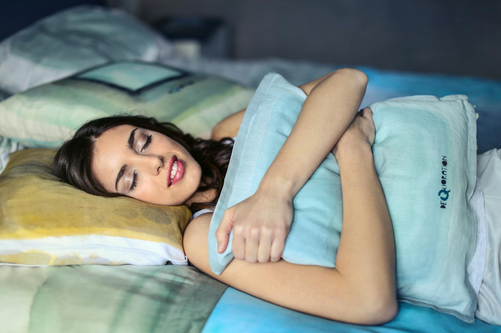 Woman-lying-in-bed-solo-time-with-pillow