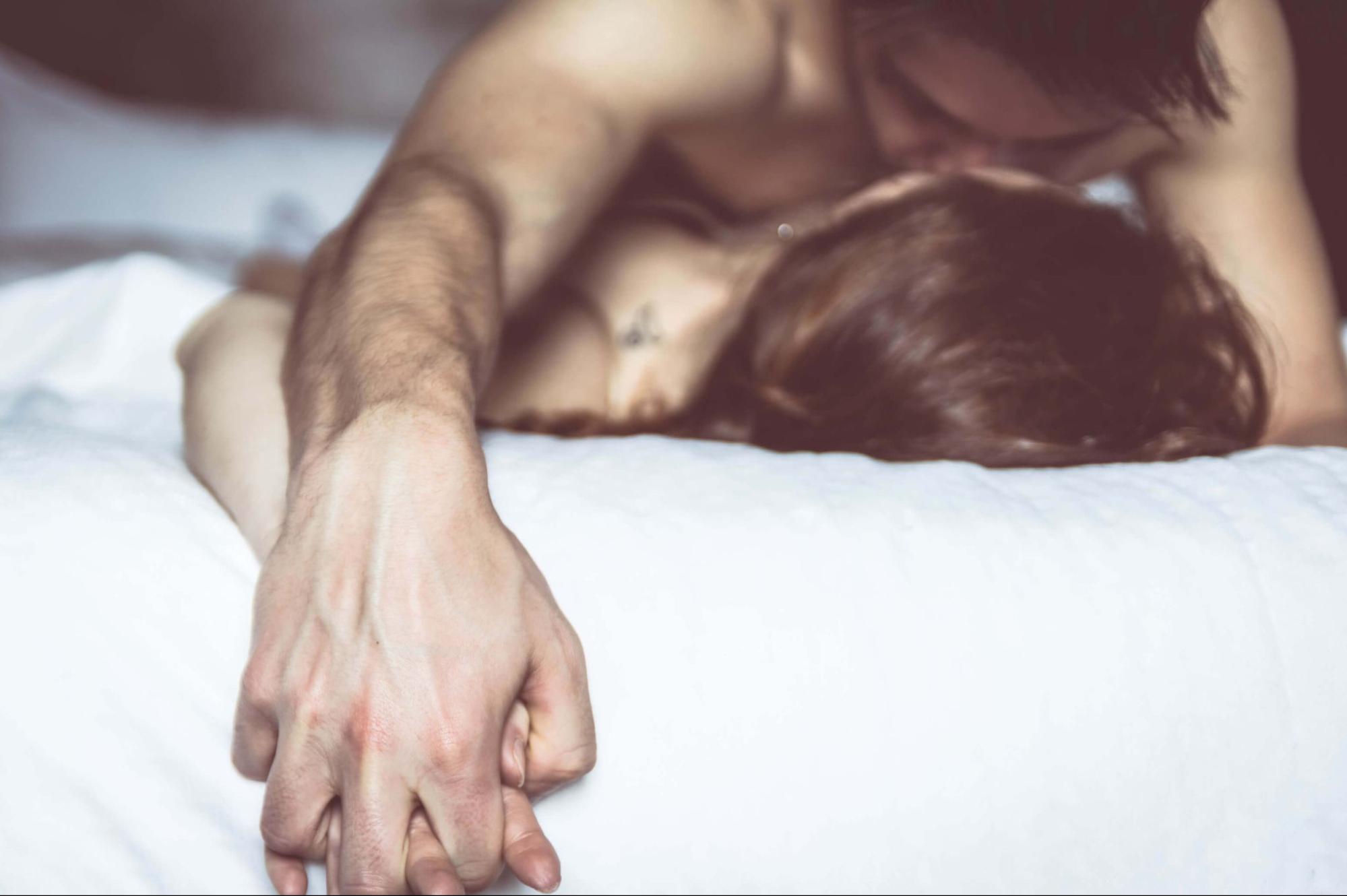 couple holding hands in bed having great orgasms